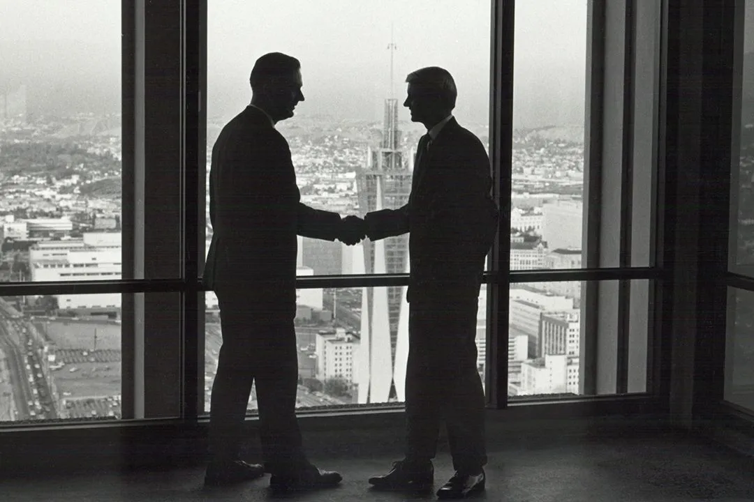 photo history shaking hands in fron of window 1960s
